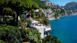 a house on the side of a mountain next to the water at Villa Il Carrubo - Amalfi Coast in Vietri sul Mare