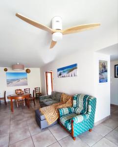 ein Wohnzimmer mit Sofas und einem Deckenventilator in der Unterkunft Maison de la famille et des amis in Biscarrosse