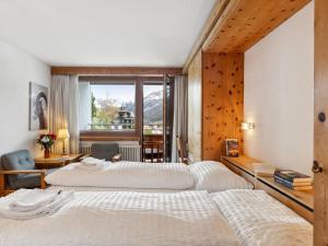 two beds in a hotel room with a window at Apartment Guardaval - Utoring-1 by Interhome in Davos +40 photos