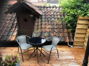 a table and chairs on a patio with a house at De Pelgrim in Tongeren