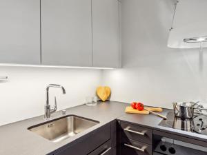 a kitchen with white cabinets and a sink at Apartment Guardaval Apt 308 by Interhome in Davos
