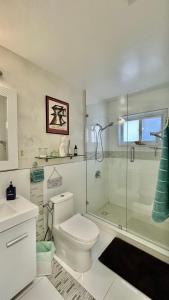 a bathroom with a toilet and a glass shower at Llano Atelier in Miami
