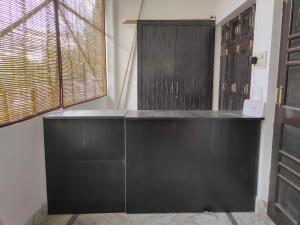a room with black cabinets and a window at Ayodhya Stays & Cafe in Faizābād +2 photos