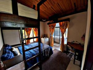 a bedroom with a bunk bed and a desk and window at Vistas Paraiso San Carlos in Venecia
