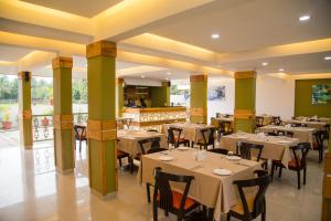 Un restaurante con mesas y sillas en una sala. en Turtle Beach Resort - Morjim, en Morjim
