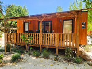 格里莫Mobil Homes Vacances的小木屋设有门廊和甲板