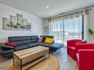 a living room with a blue couch and a red chair at Villa Les Alyzés by Interhome in Vensac
