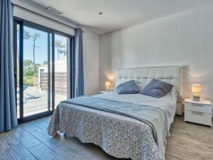 a bedroom with a bed and a large window at Villa Les Alyzés by Interhome in Vensac