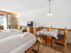 a bedroom with a bed and a table and chairs at Apartment Guardaval Apt 107 by Interhome in Davos