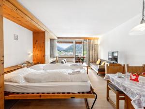a bedroom with a large bed and a couch at Apartment Guardaval Apt 107 by Interhome in Davos +40 photos