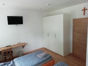 a room with a bed and a cross on the wall at Zum Schulhaus in Burglengenfeld