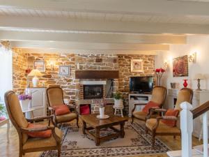 a living room with chairs and a stone fireplace at Holiday Home Les Hortensias by Interhome in Kerherneau