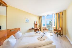 ein Hotelzimmer mit einem Bett mit Handtüchern darauf in der Unterkunft Arkona Strandhotel in Binz