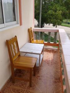 two chairs and a table on a porch at Lanta Orange House in Ko Lanta