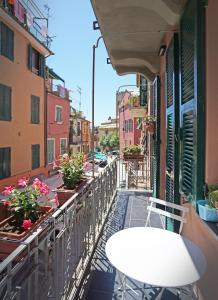a balcony with a white table and flowers on a street at allegra suites in Monterosso al Mare