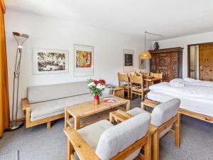 a bedroom with two beds and a table and chairs at Apartment Guardaval - Utoring-9 by Interhome in Davos