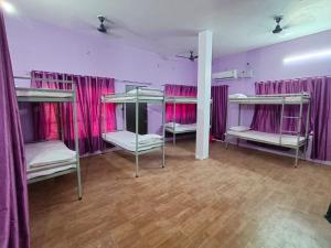 a room with four bunk beds with pink curtains at Ayodhya Stays & Cafe in Faizābād