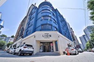 a blue building with cars parked in front of it at Hotel Lion in Cheongju