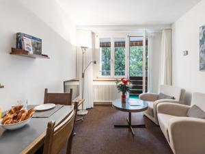 a living room with a table and a couch at Apartment Parkareal - Utoring-6 by Interhome in Davos