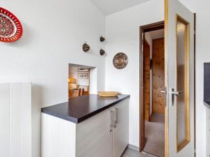 a kitchen with white cabinets and a black counter top at Apartment Guardaval Apt 202 by Interhome in Davos +45 photos