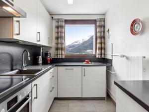 a kitchen with white cabinets and a window at Apartment Guardaval Apt 202 by Interhome in Davos
