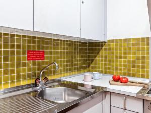a kitchen with a sink and green tiles at Apartment Guardaval Apt 508 by Interhome in Davos