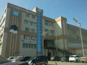 un edificio con coches estacionados en un estacionamiento en Moy Uyutniy Dom Hotel, en Kurgán