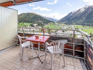 a table and chairs on a balcony with mountains at Apartment Guardaval Apt 508 by Interhome in Davos