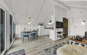 a kitchen and living room with a table and chairs at Holiday Home Sdr Klitvej Hvide Sande Denm in Havrvig