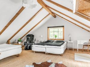 a attic bedroom with two beds and a window at Chalet Bäcklunda by Interhome in Mullhyttan