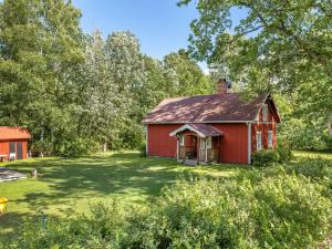an old red barn in the middle of a yard at Chalet Bäcklunda by Interhome in Mullhyttan