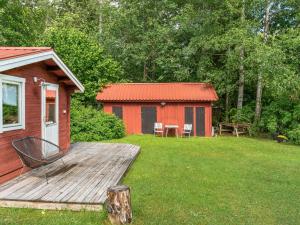a cabin with a deck and a table and chairs at Chalet Bäcklunda by Interhome in Mullhyttan
