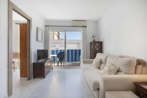 ein Wohnzimmer mit einer Couch und einem Tisch und einem Fernseher in der Unterkunft Plata Ático in Torremolinos