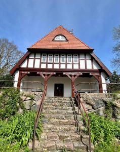 a house with stairs leading up to a building at Großes Ferienhaus an der Ostsee "Oldevighus" in Hohenkirchen
