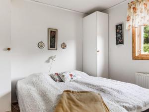 a bedroom with white walls and a white bed at Holiday Home Matvikshamn by Interhome in Trensum