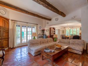 a living room with a couch and a table at Holiday Home L'Oliverede by Interhome in La Garde-Freinet