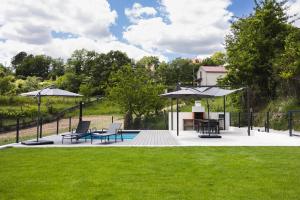 a patio with chairs and umbrellas in a yard at Casa do Lagar in Paradela