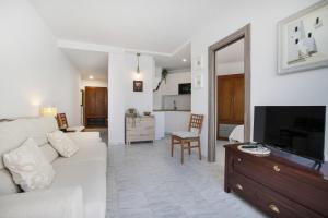 ein Wohnzimmer mit einem weißen Sofa und einem Fernseher in der Unterkunft Plata Ático in Torremolinos