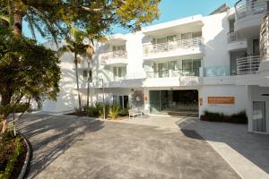 an exterior view of a white apartment building at Sunwing Alcudia Beach in Alcudia