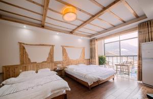 张家界Hongfu Villa - Zhangjiajie National Forest Park West Gate的一间有两张床和一扇大窗户的卧室
