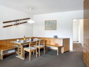 a dining room with a wooden table and chairs at Apartment Parkareal - Utoring-49 by Interhome in Davos +32 photos