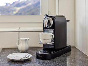 a coffee maker with two cups on a counter at Apartment Guardaval - Utoring-66 by Interhome in Davos