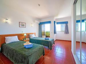 a hotel room with two beds and two windows at Apartment Estrela do Vau Apart- 3 bedroom-3 by Interhome in Portimão
