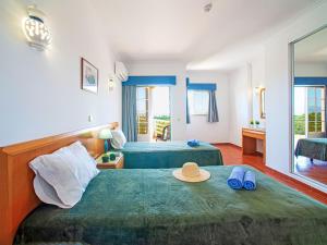 a bedroom with two beds with a hat and flip flops at Apartment Estrela do Vau-3 bedroom-3 by Interhome in Portimão