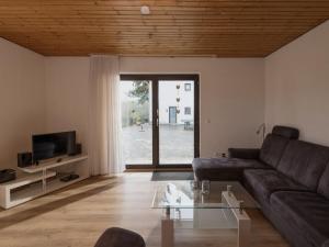 a living room with a couch and a glass table at Holiday Home Eifelnatur - Haus 2-4 by Interhome in Immerath