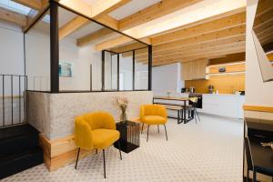 a kitchen and living room with yellow chairs and a counter at Casa do Lagar in Paradela