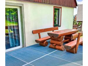 a picnic table and bench on a porch at Holiday Home Holiday Hill 65 by Interhome in Lauterwasser