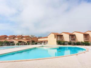 una piscina di fronte ad alcune case di Holiday Home Bastides de la Mer-1 by Interhome a Le Barcarès