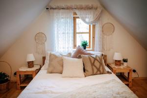 a bedroom with a bed with pillows and a window at Sielsko in Lipsko-Polesie