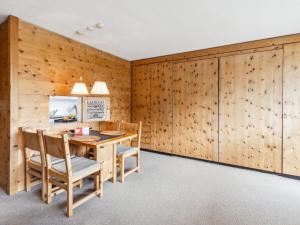 a dining room with wooden walls and a wooden table and chairs at Apartment Guardaval - Utoring-44 by Interhome in Davos